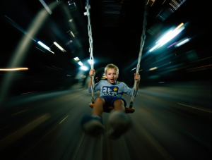 a boy sitting on a swing, high-speed, motion blur, action-packed, dramatic lighting, intense, dynamic angles